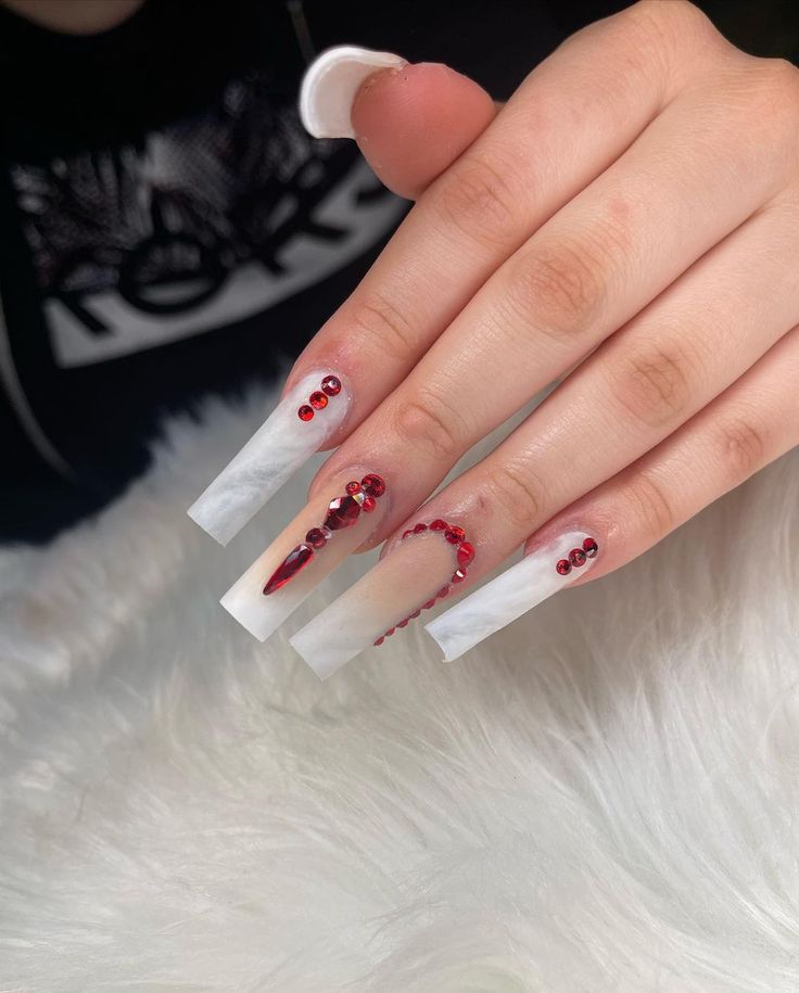 Elegant Long Sculpted Nails with Striking Marble and Glossy Finishes, Enhanced by Deep Red Embellishments and Sparkling Gems.