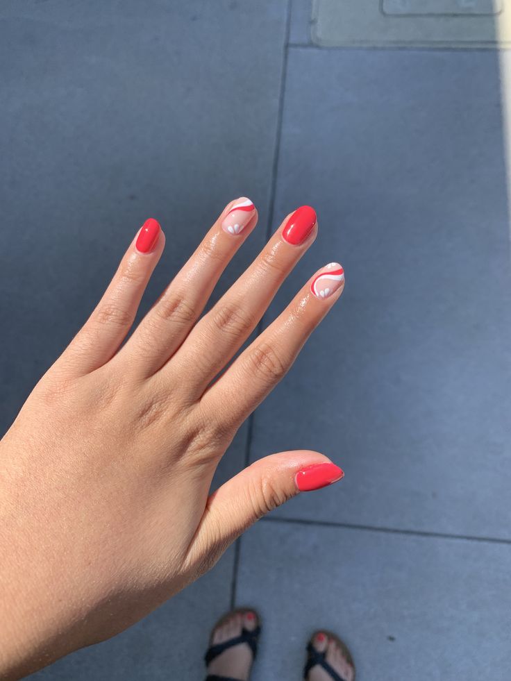 Vibrant Red Nail Design with Playful White and Pink Swirls for a Striking Aesthetic.