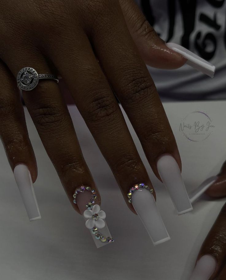 Sophisticated Long Matte White Nails with Floral and Rhinestone Accents.