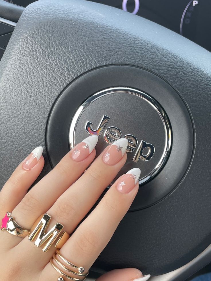 Chic Nail Design: Soft Nude Base with Striking White Tips and Whimsical Star Accents.