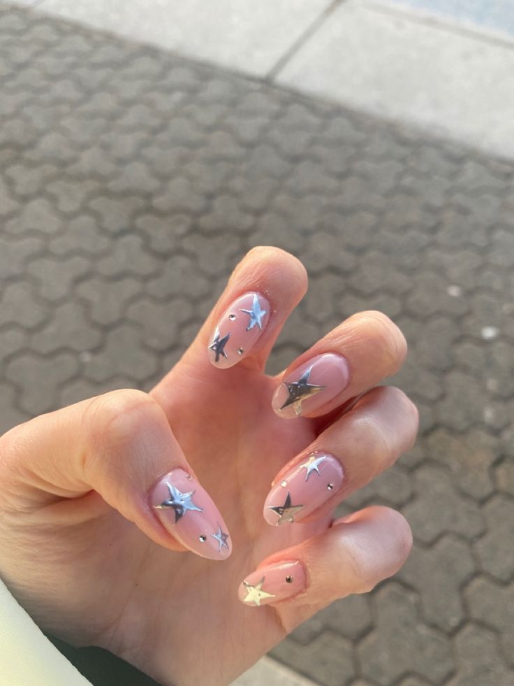 Whimsical Pink Star-themed Nail Design with Silver Embellishments and Rhinestones.