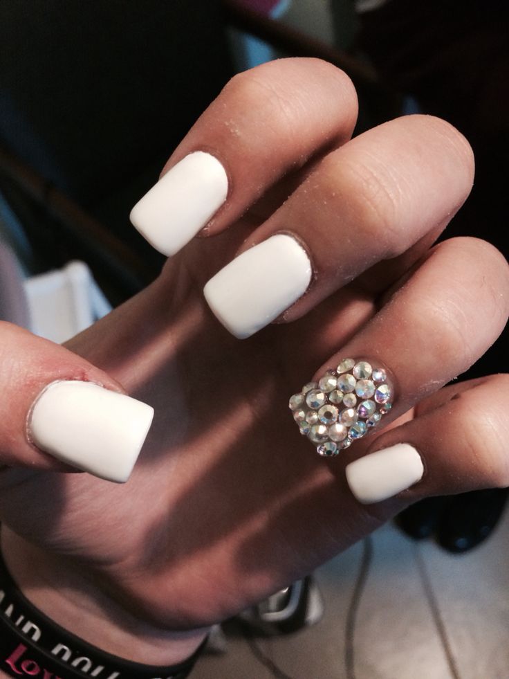 Elegant White Nails with a Glamorous Rhinestone Accent for a Sophisticated Look.