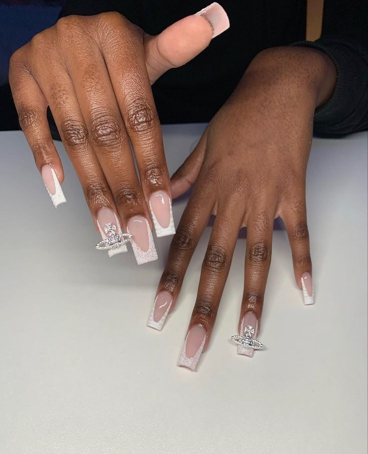 Elegant Long Nude Nails with White Tips and Sparkling Embellishments for a Glamorous Look.