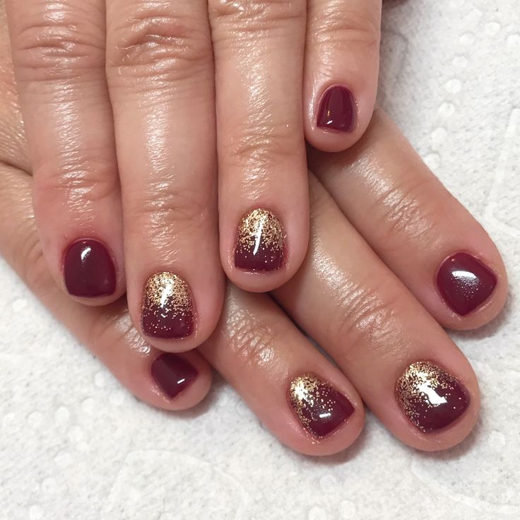 Sophisticated Garnet and Gold Nail Design with Matte and Shimmer Finishes.