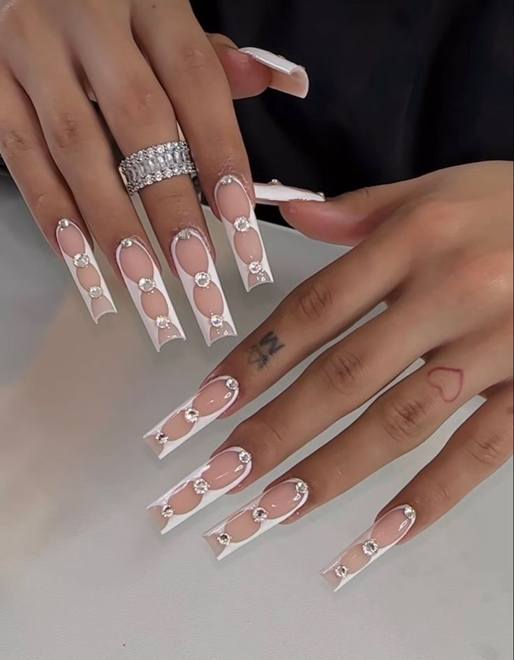 Chic Long Rectangular Nail Design with Nude and White Colors, Featuring Rhinestone Embellishments for Sophisticated Glamour.