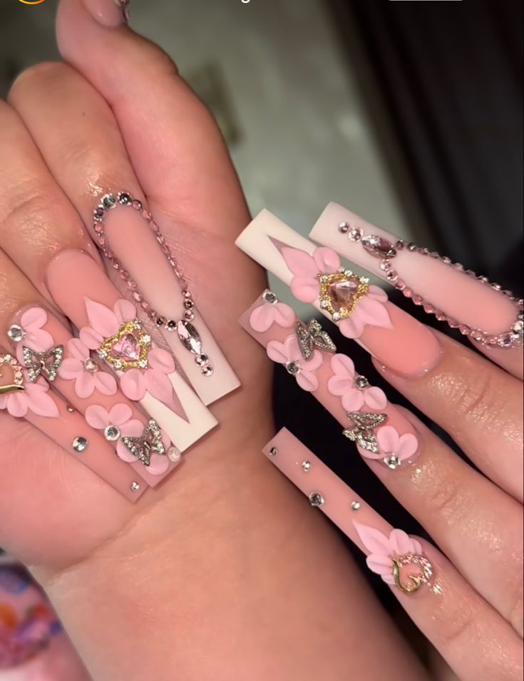 Whimsical Nail Design with Pink Hues, 3D Floral Motifs, and Sparkling Accents.