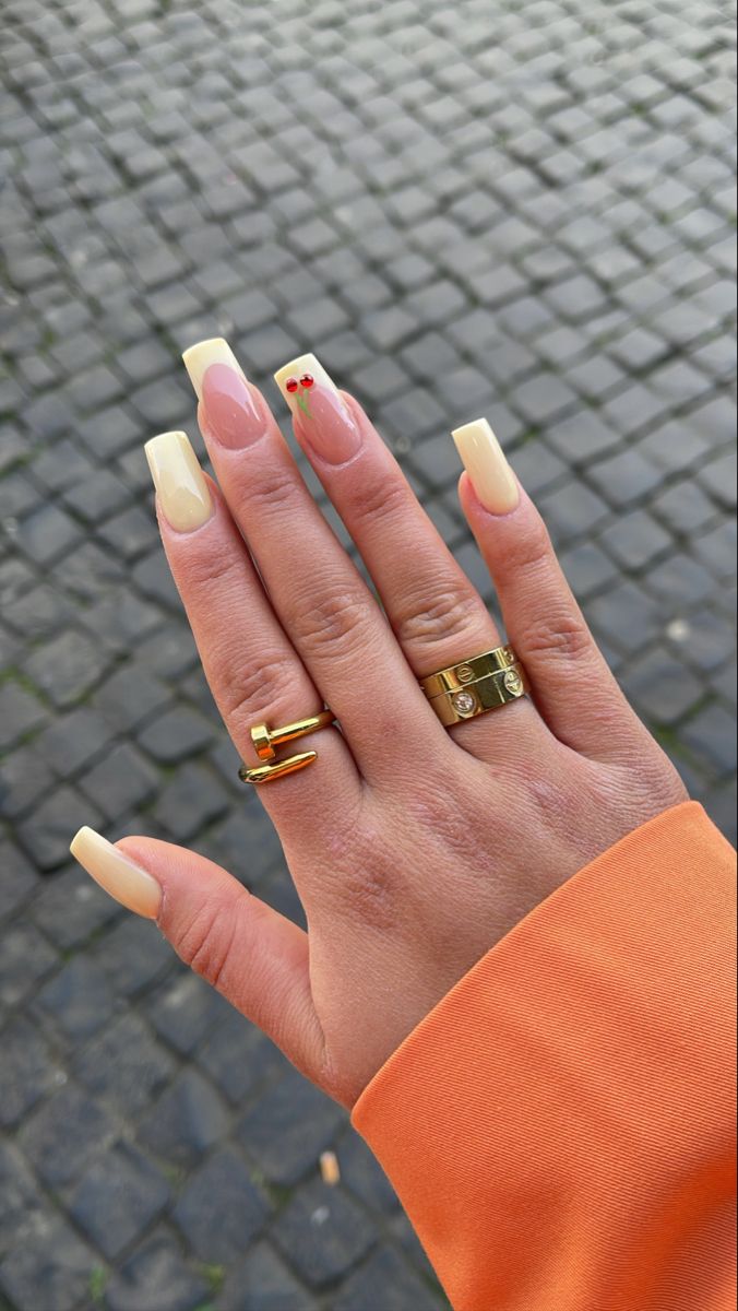 Chic Pastel Yellow Nail Design with Playful Cherry Accents and Gold Rings