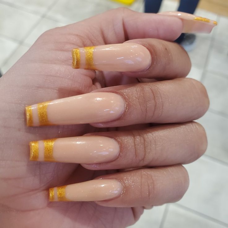 Chic Elegant Nude Nails with Glossy Finish and Bold Gold Tips.