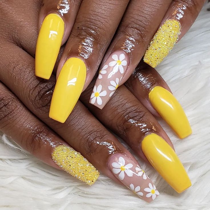 Cheerful Yellow Nail Design with Floral Accent and Sparkling Glitter.