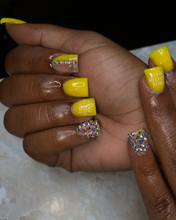 Bold Yellow Nails with Glossy Finish and Dazzling Rhinestone Accents.