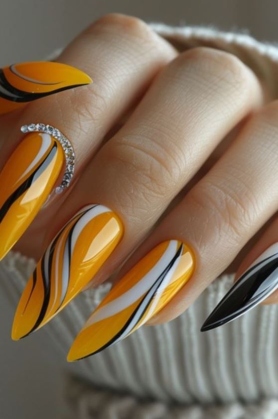 Striking Almond-Shaped Manicure: Vibrant Yellow and Glossy Black with Elegant Swirls and Rhinestone Glamour.