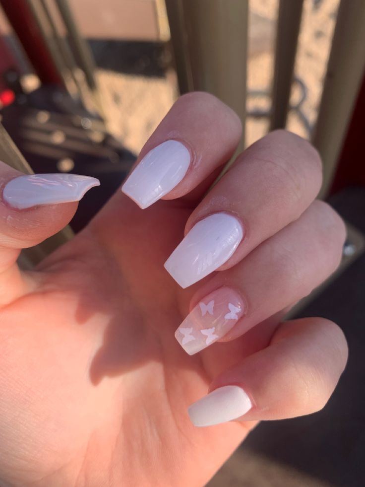 Chic White Nail Design with Elegant Butterfly Accents for a Modern, Playful Look.