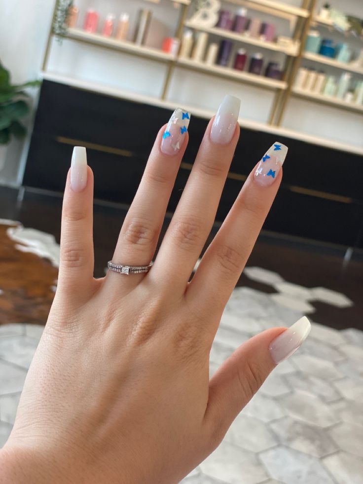 Sophisticated Ombre Nail Design with Playful Blue Butterfly Accents