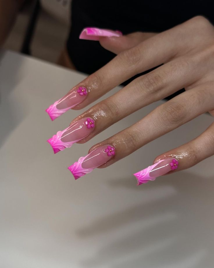 Bold Pink Gradient Nail Design with Floral Accents and Glossy Finish.