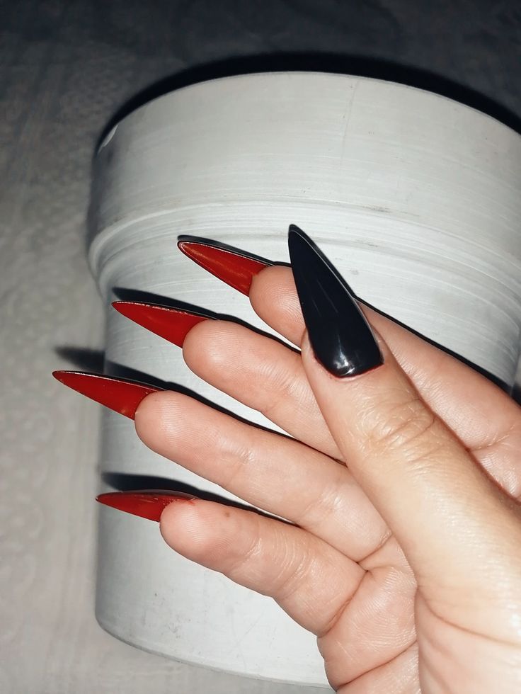 Bold Dual-Color Stiletto Nails: Glossy Black with Vibrant Red Tips for a Dramatic Statement.