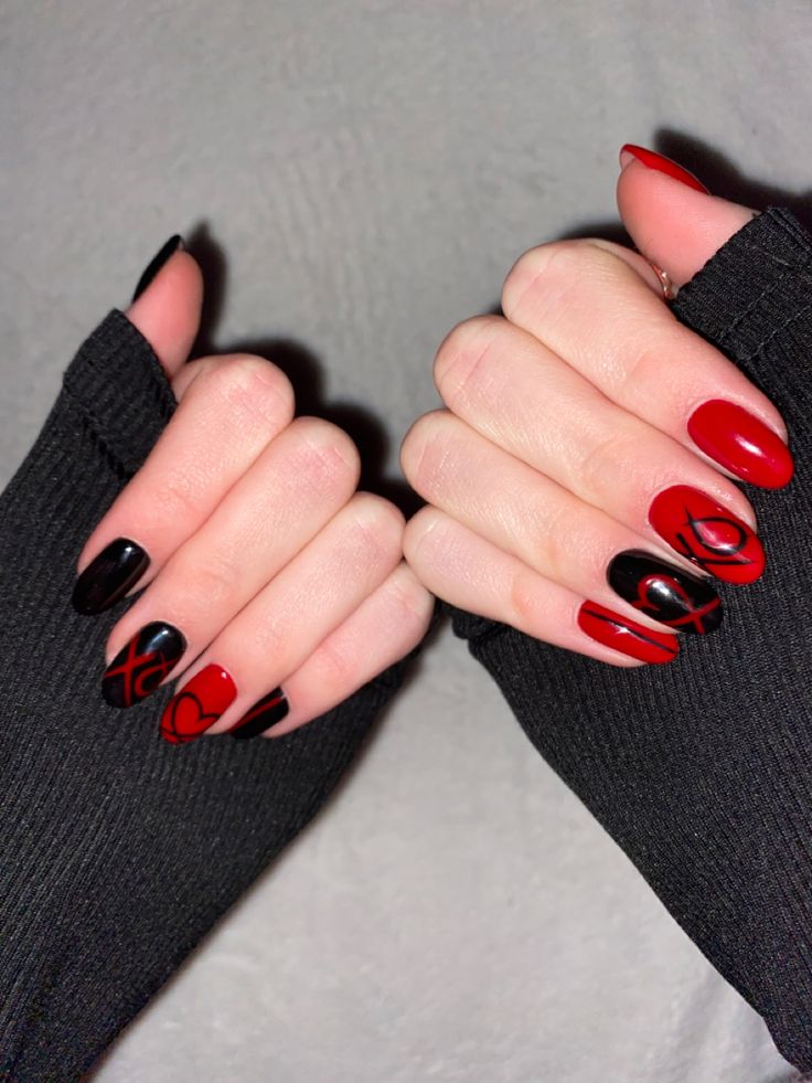 Striking Nail Design: Bold Red and Black with Intricate Patterns for Dramatic Impact.