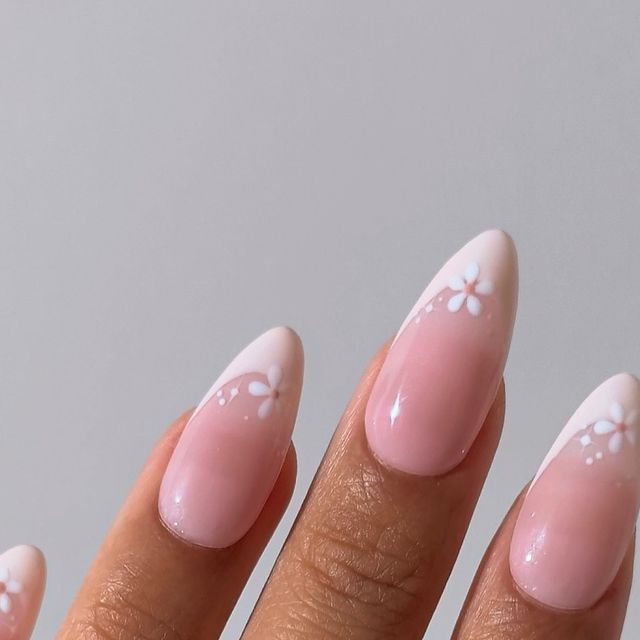 Chic Pink Ombre Nails with Whimsical White Flowers for a Playful Spring Aesthetic.