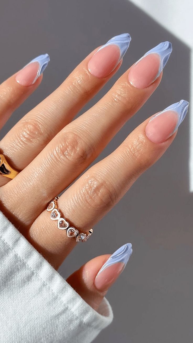 Chic Pink and Light Blue Pointed Nail Design with Swirl Patterns and Understated Rings.