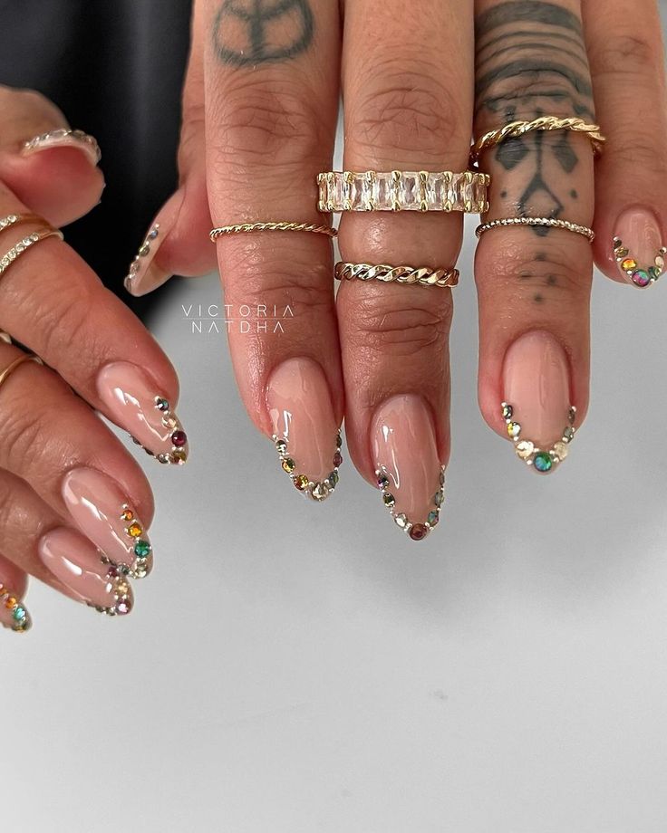 Chic French Tip Nail Design with Colorful Rhinestone Accents and Elegant Rings