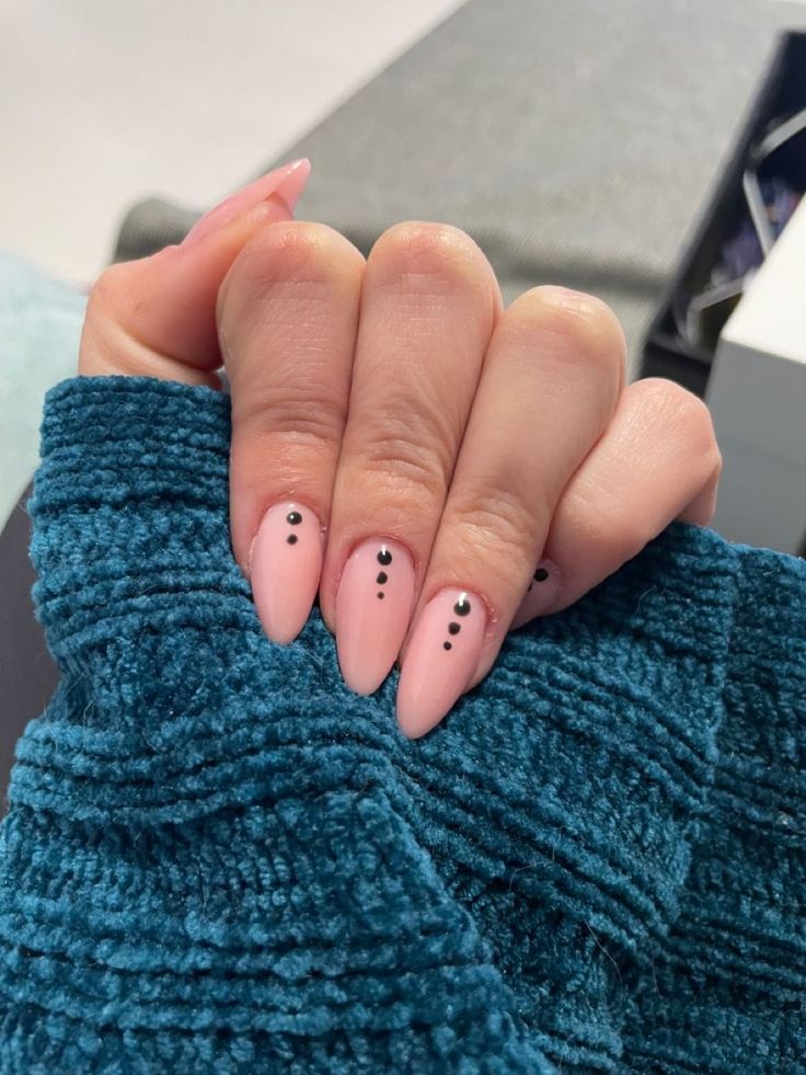 Chic Almond-Shaped Nails with Blush Pink Polish and Delicate Black Dot Accents.