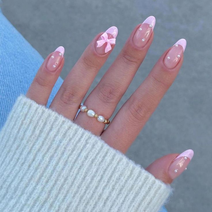 Chic Soft Pink French Tip Nails with Pastel Accents and Playful Bow Detail.