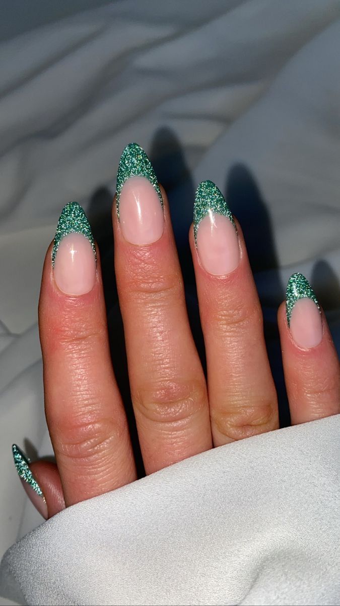 Stylish Elongated French Tip Nails with Shimmering Green Glitter on a Nude Base.