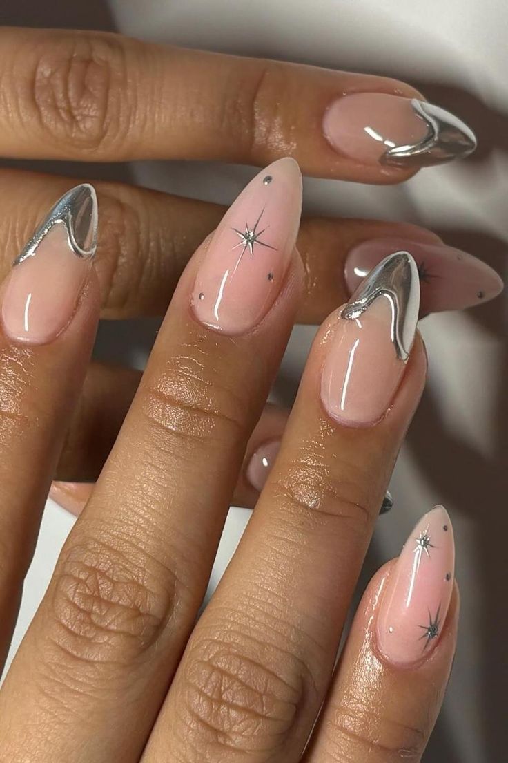 Chic Asymmetrical Stiletto Nail Design in Nude and Silver with Star Accents.