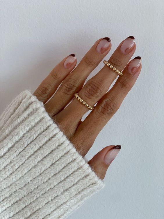 Sophisticated Ombre Nail Design with Nude Base and Brown Tips, Enhanced by Gold Accents.