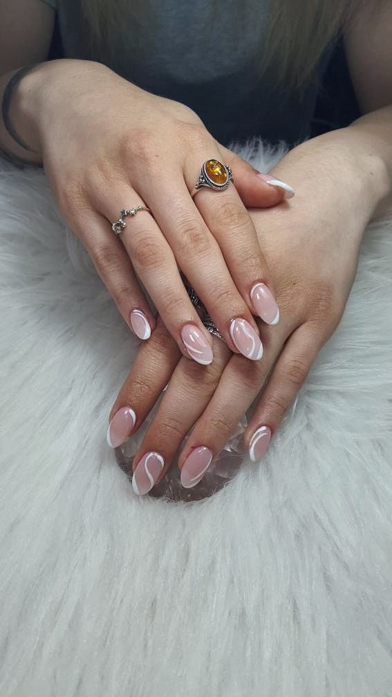 Sophisticated Nude Nail Design with Delicate White Swirls and Glamorous Accents.