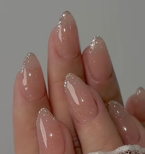 Chic Glittery French Tip on Elegant Nude Nails for a Sophisticated Look.