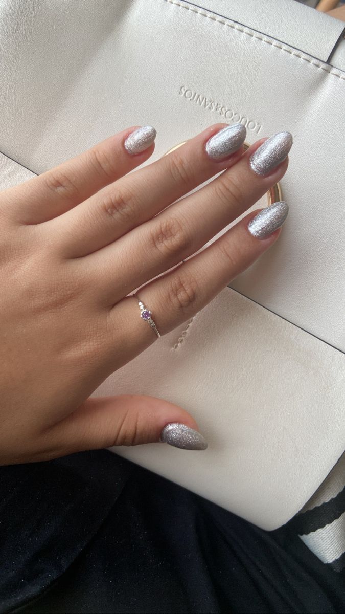 Glamorous Sparkly Silver Almond Nails Enhanced by a Chic Ring.