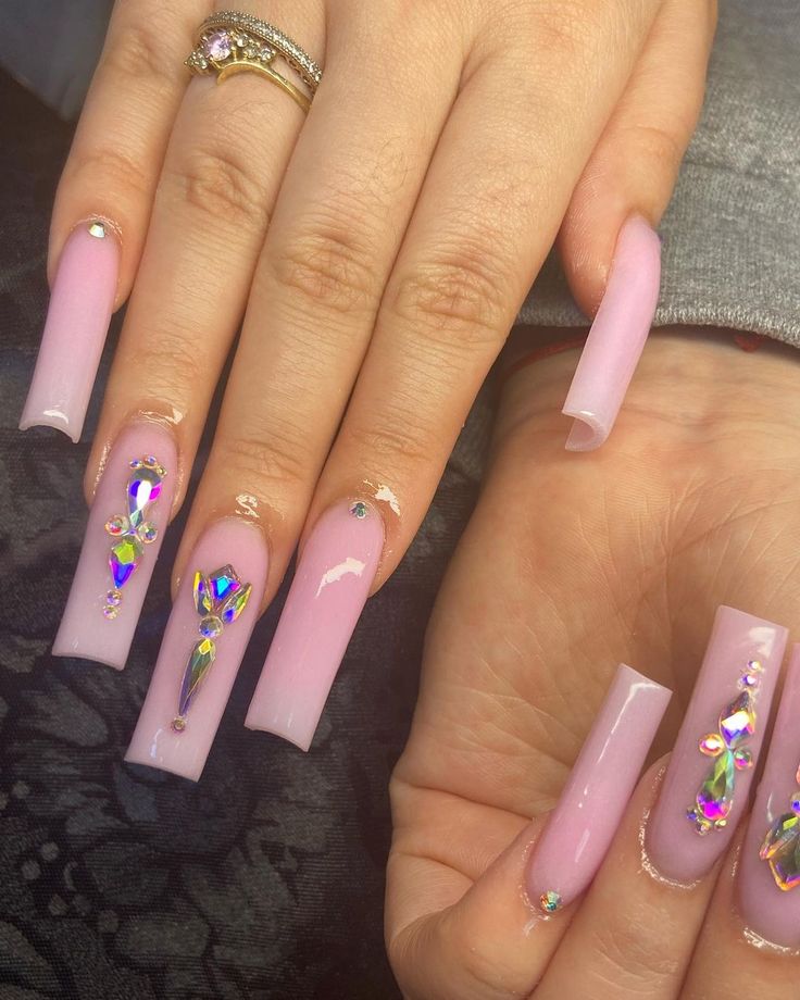 Chic Soft Pink Nails with Shimmering Crystal Designs for a Glamorous Look.