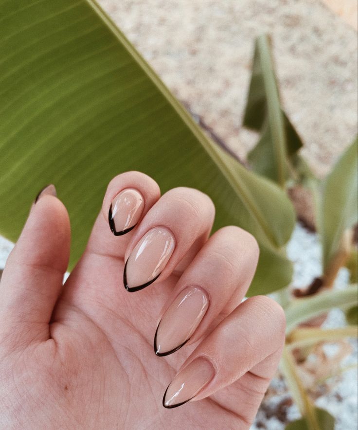 Chic Almond-Shaped Nails: Elegant Nude Base with Bold Black Tips for a Stylish Statement.