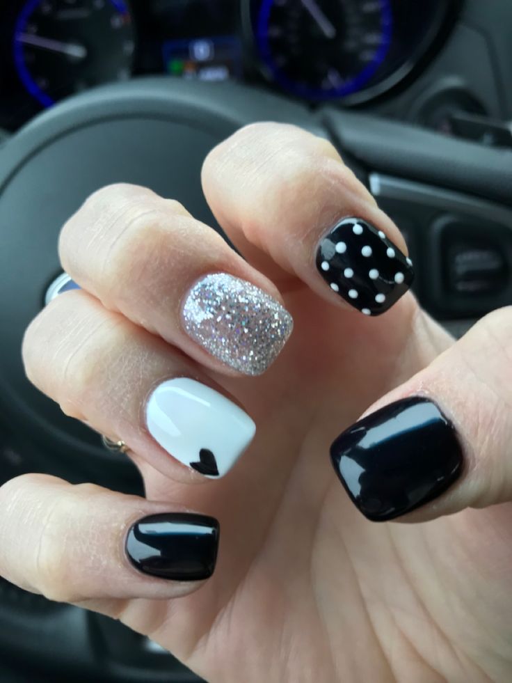 Chic Nail Art: Bold Black and White with Glam Glitter and Heart Accents.