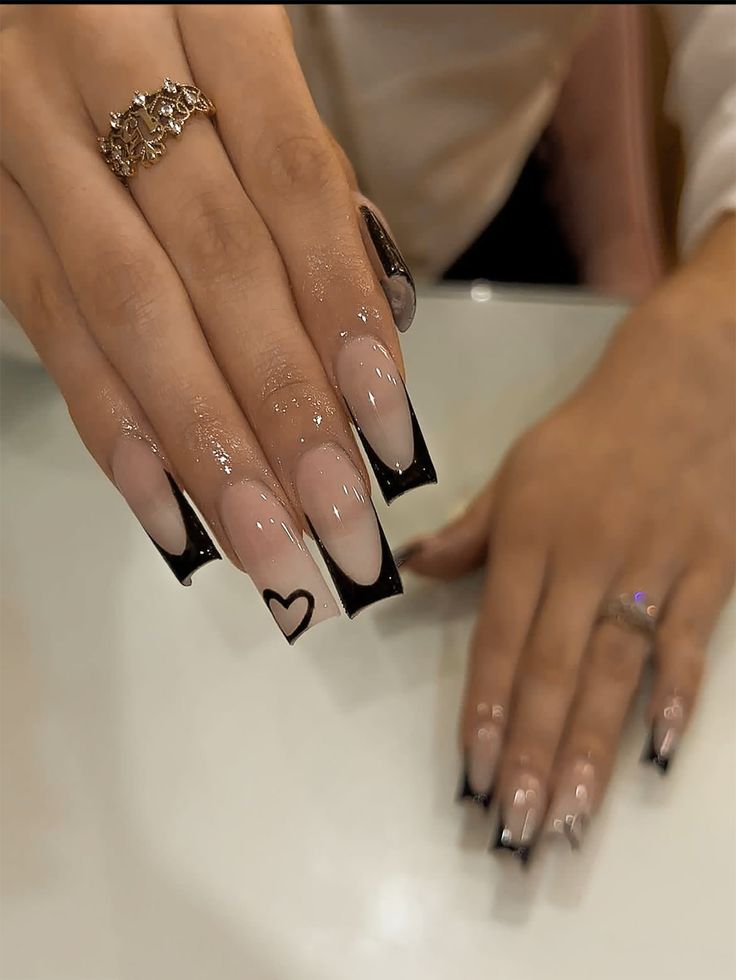 Elegant Nail Design: Chic Nude and Black Tips with Heart Accent