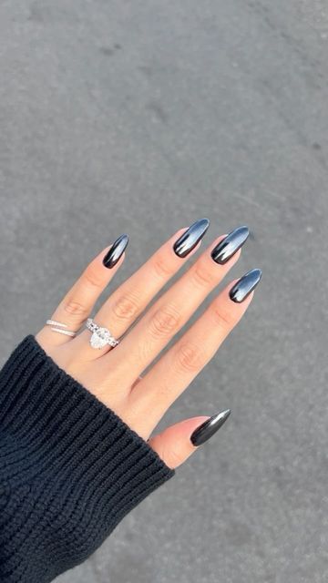 Striking Chic Black and Silver Ombre Almond Nails with Elegant Accent Ring.