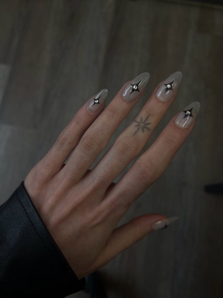 Sophisticated Long Nails: Soft Nude Polish with Delicate Black Stud Accents for a Chic Look.