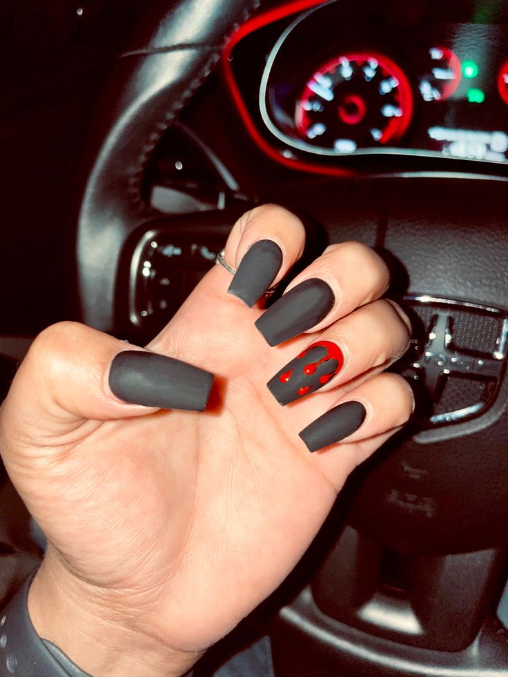 Edgy Matte Black Nails with Glossy Accents and Bold Red Highlights