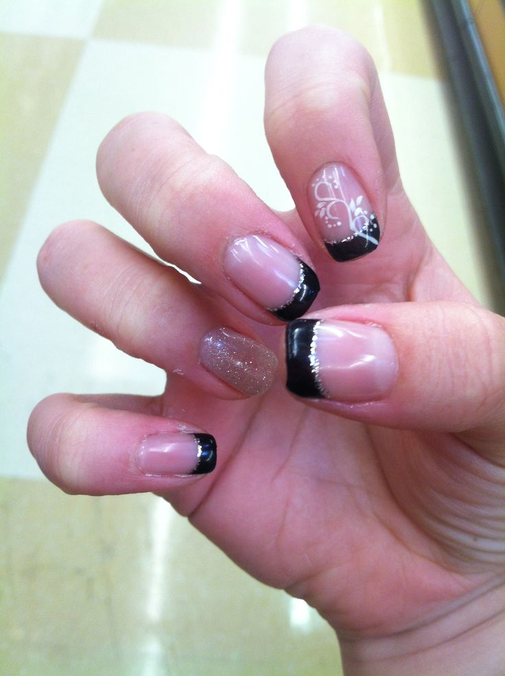 Striking Nude and Black Nail Design with Floral Accents and Sparkling Gradient.