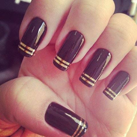 Sophisticated Black Nails with Gold Stripes: A Timeless Glamour.