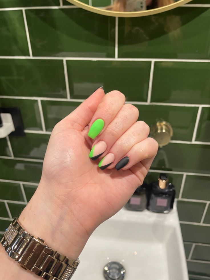 Vibrant Geometric Nail Art: A Unique Blend of Green, Nude, and Black with a Modern Matte Finish.