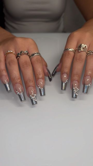 Elegant Elongated Nails: A Chic Blend of Glossy Nude and Metallic Silver Finishes with Glamorous Embellishments.