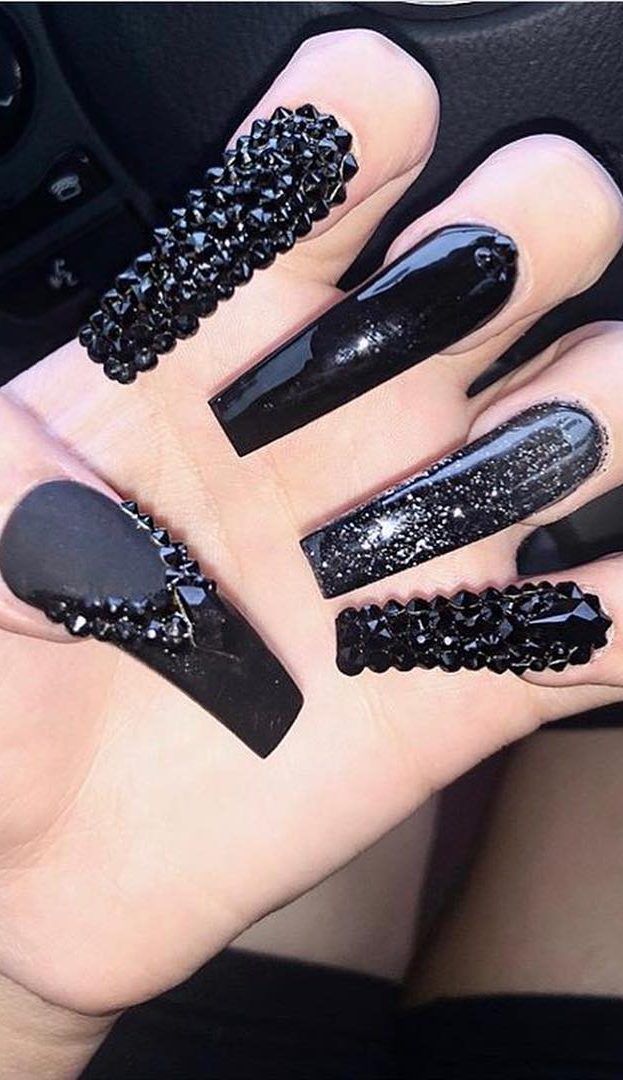 Bold Black Nail Design with Glossy Smoothness and Textured Sparkling Accents.