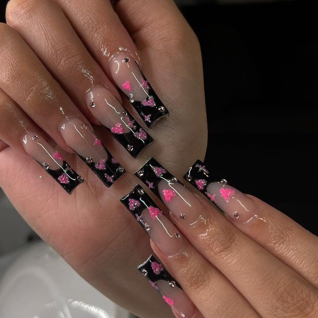 Elegant Black and Clear Nail Design with Pink Floral Accents and Glossy Finish.