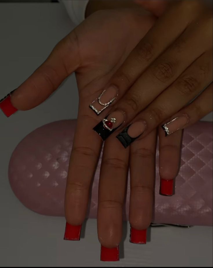 Chic Bold Red and Black Nail Design with Glamorous Geometric Embellishments.