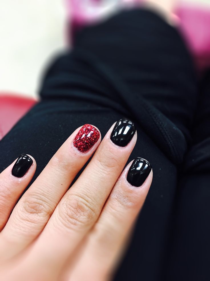 Elegant Black Manicure with Bold Red Glitter Accent for Glamorous Contrast.