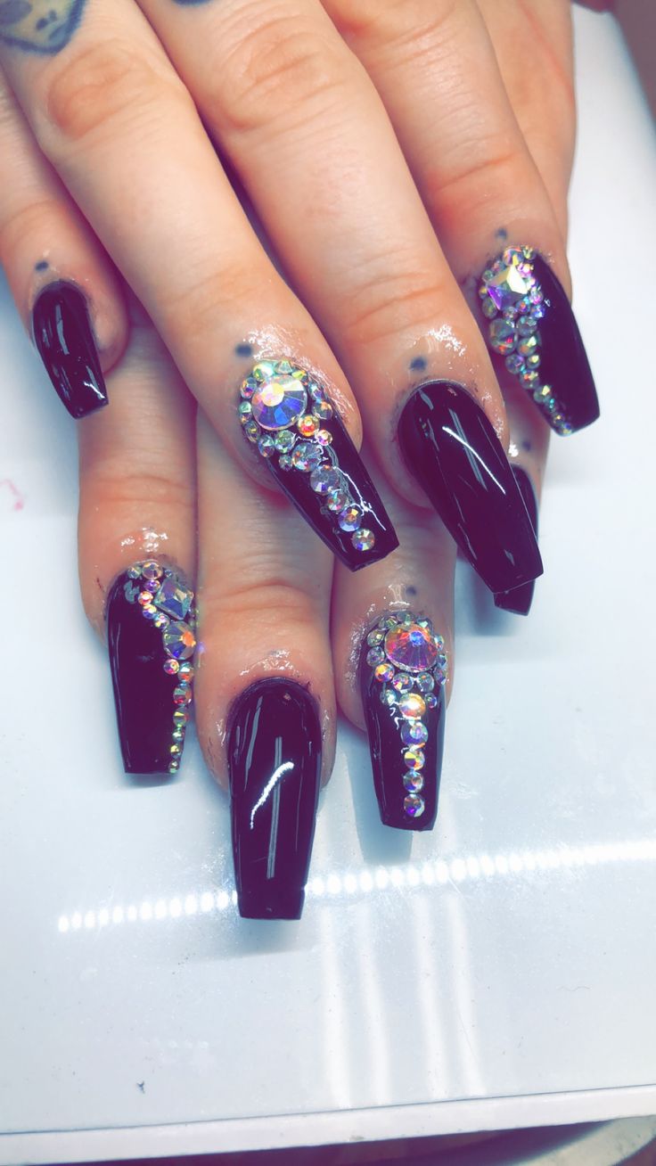 Glamorous Black Acrylic Nails Adorned with Colorful Rhinestone Patterns.