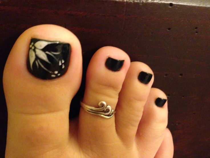 Sophisticated Nail Design: Glossy Black Finish with Floral Motif and Silver Accents.