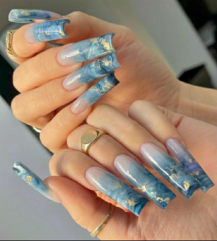 Elegant Blue Marbled Nail Design with Gold Accents and Tapered Shapes