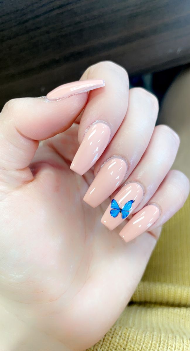 Chic Glossy Nude Nails with Striking Blue Butterfly Accent for an Elegant Yet Playful Look.